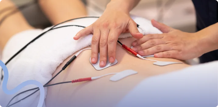 Therapist placing electrical stimulation electrode pads on a patient's lower back