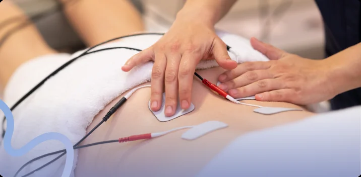 Electrode pads with leads placed on a patient's lower back during an e-stim therapy session