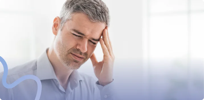 Man pressing his fingers to his temple with his eyes closed from headache pain