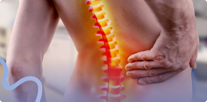 Highlighted spine graphic over a man's lower back as he holds his hip in pain