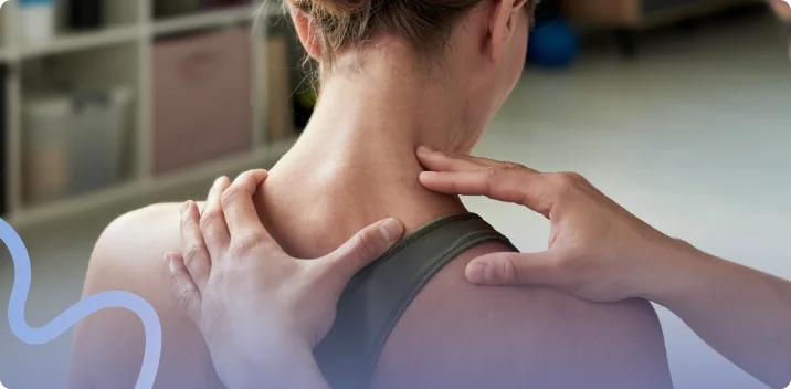 Massage therapist using both hands to work on a patient's neck and shoulder muscles