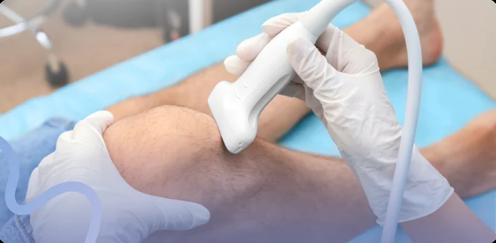 Provider in white gloves gliding a therapeutic ultrasound wand over a patient's knee